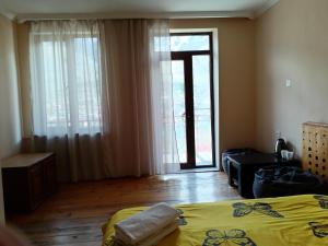 a bedroom with a bed and a sliding glass door at Belas guesthouse in Stepantsminda