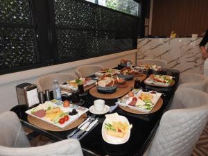 una mesa larga con platos de comida. en The Rooms Boutique Otel en Kumbağ