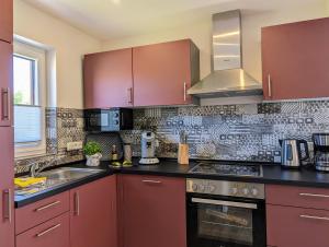 a kitchen with red cabinets and a sink at Premiumferienhaus Mara in Hasselfelde