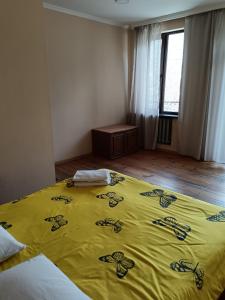 a bedroom with a yellow blanket on a bed at Belas guesthouse in Stepantsminda