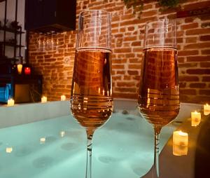 two glasses of champagne sitting on top of a hot tub at Suites romantiques spa privatif, piscine, jardin, massages proche de Toulouse in Verfeil