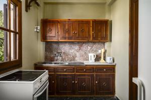 una cucina con mobili in legno e un forno a piano cottura di Aurora Beach House a Sidari