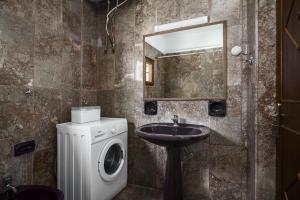 un bagno con lavatrice e lavandino di Aurora Beach House a Sidari