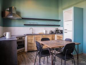 a kitchen with a wooden table and chairs in it at Charmant T1 calme et reposant in Saint-Andiol