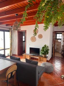 Una sala de estar con un sofá y un televisor. en Casa Volcán, en La Costa 4 fotos más