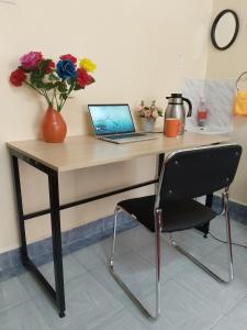 a desk with a laptop and a chair at Cozy Nest-2 Bedroomed Apartment WiFi ,Netflix close to JKIA in Syokimau