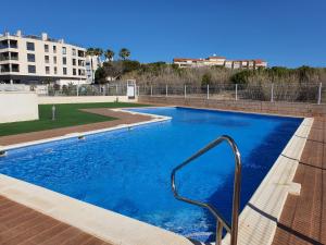 ein großes blaues Schwimmbecken mit einem Metallhandlauf in der Unterkunft AL048 Pinada Beach IV La Mata in La Mata