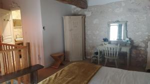 1 dormitorio con cama, mesa y espejo en Barn cottage en La Tour-Blanche