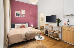 um quarto com uma cama e uma parede roxa em TurnKey I Downtown Studio em Praga