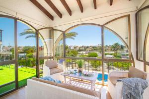 a living room with large windows and a table at Villa Cohete - Plusholidays in Ifach