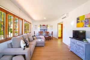 a living room with a couch and a tv at Villa Cohete - Plusholidays in Ifach