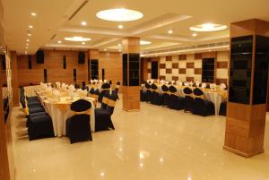 a banquet hall with white tables and chairs at Glades Hotel in Chandīgarh