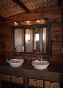 baño con 2 lavabos y espejo grande en Nuwefonteinskop Lodge en Kotzesrus