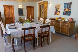 Nuwefonteinskop Lodge في Kotzesrus: غرفة طعام مع طاولة بيضاء وكراسي