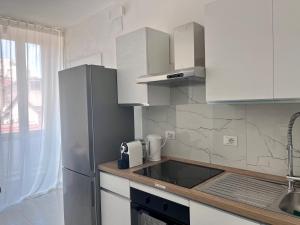 a kitchen with white cabinets and a refrigerator at BeB CASAMA - Ortona Rooms in Ortona