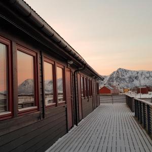ein Haus mit einer Terrasse mit Bergen im Hintergrund in der Unterkunft Marmelkroken AS in Bø Andøya
