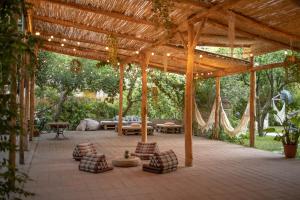 eine überdachte Terrasse mit Sofas und einer hölzernen Pergola in der Unterkunft HOPESTEL Secret Garden Napoli in Neapel