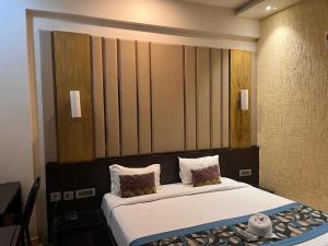 - une chambre dotée d'un grand lit avec des draps et des oreillers blancs dans l'établissement HOTEL JODHA THE GREAT, à Agra