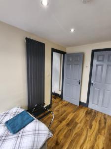 une pièce vide avec un lit et deux portes dans l'établissement 133 A Park Road, à Manchester