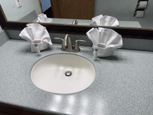 a bathroom sink with towels on a counter at Promenade Inn & Suites Oceanfront in Seaside