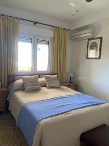 a large bed in a bedroom with two windows at Apartamento Lucia in Roquetas de Mar