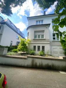 une maison blanche avec un escalier en face de celle-ci dans l'établissement Souterrain Wohnung in einer Stadtvilla, à Hagen