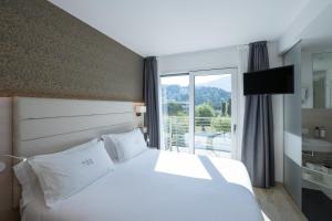 a hotel room with a bed and a large window at Hotel Bellariva in Riva del Garda +79 photos