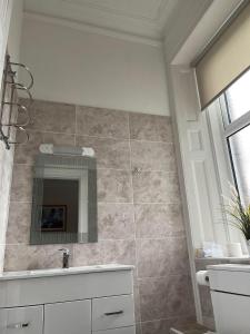 uma casa de banho com um lavatório e um espelho em The Strathearn Hotel em Fife