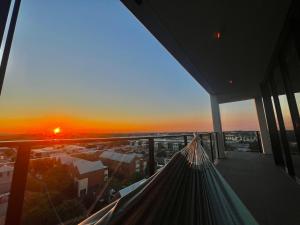 uma vista para o pôr-do-sol a partir de um edifício em Harbour Towers, Newcastle's Luxe Apartment Stays em Newcastle