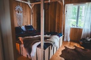 a bedroom with two beds in a wooden room at Off the grid in the abandoned village of Ejheden in Voxnabruk