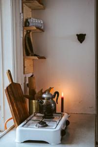 a tea kettle on a stove with a candle at Off the grid in the abandoned village of Ejheden in Voxnabruk