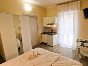 Una pequeña habitación con una cama y una cocina. en La Corte del Maggiore, en Parma