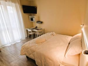 Un dormitorio con una cama blanca y una mesa. en La Corte del Maggiore, en Parma