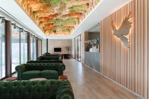 um lobby com sofás verdes e um teto com uma pintura em Pousadela Village & Spa em Vieira do Minho