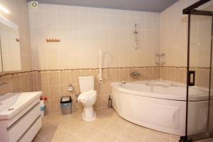 a bathroom with a tub and a toilet and a sink at Tokgoz Butik Hotel&Apartment in Oludeniz