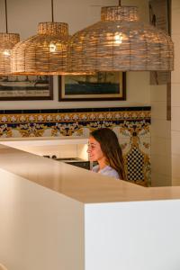 une femme assise à un comptoir dans une cuisine dans l'établissement Hotel Marina, à Roses