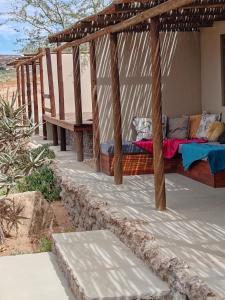 Nuwefonteinskop Lodge في Kotzesrus: شرفة مع سرير وكراسي عليها
