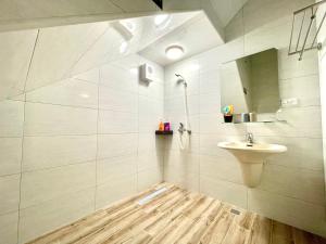 La salle de bains blanche est pourvue d'un lavabo et d'un miroir. dans l'établissement Banshan Yunxiu Homestay, à Jinning