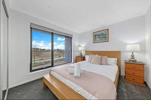 a bedroom with a bed and a large window at Brand New Home In Oran Park in Narellan