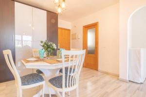 a dining room with a white table and chairs at Apt Parque Fuengirola 800mt From Sea - Happy rentals in Fuengirola