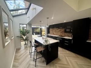 a kitchen with a table and some chairs in it at Casa 135, Sauna, Firepit, BBQ in Ringwood
