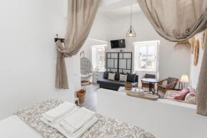 a bedroom with a bed and a living room at Floripes Stylish in Olhão