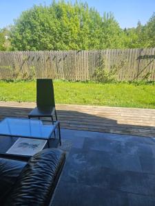 a patio with a couch and a glass table with a laptop at Montana Guest House. in Lillestrøm