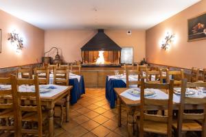 Hotel Conde De Badaran في Badarán: غرفة طعام مع طاولات وكراسي ومدفأة