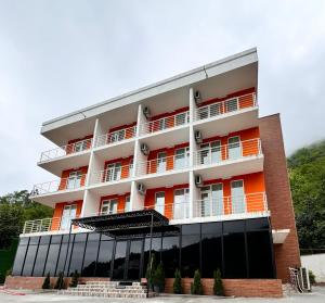 un edificio de color naranja y blanco en Orange Villa Kvariati en Kvariati