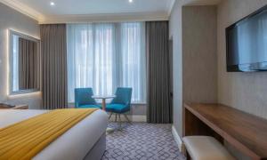 um quarto de hotel com uma cama e uma televisão de ecrã plano em Albany House em Dublin