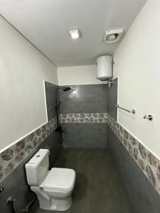 uma casa de banho com um WC branco num quarto em Ambulugala Home Stay em Gampola