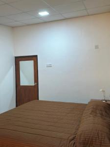 ein Schlafzimmer mit einem Bett mit einer Tür und einem Spiegel in der Unterkunft Ambulugala Home Stay in Gampola