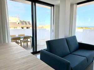 un salon avec un canapé bleu et une table dans l'établissement Ático Lamar Spa Golf Playa, à Pilar de la Horadada