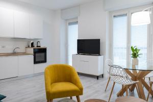 a living room with a yellow chair and a table at Casa Mila in Milan